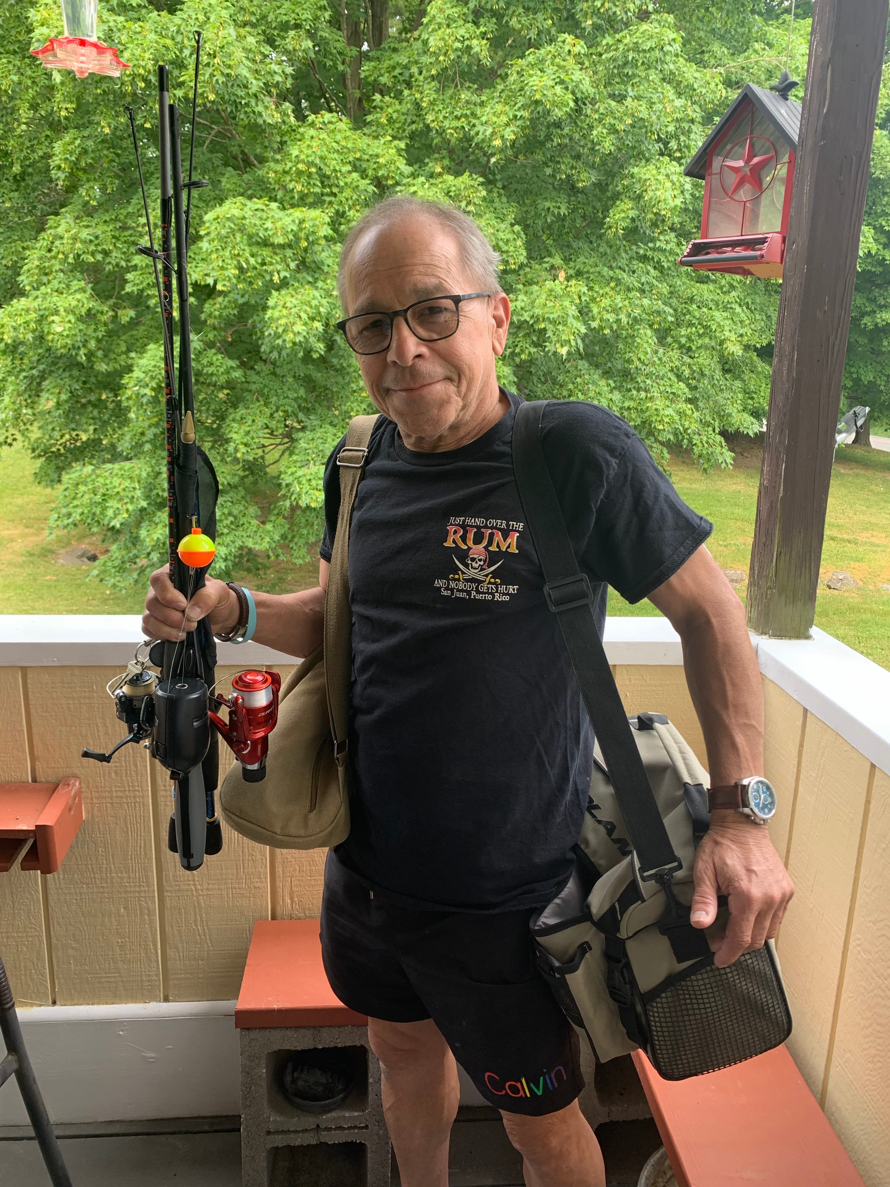 Harold holding fishing rods on a deck